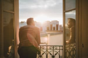 person on balcony staring out at city