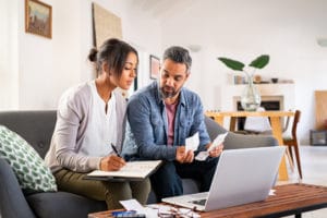 two people examining notes by a computer